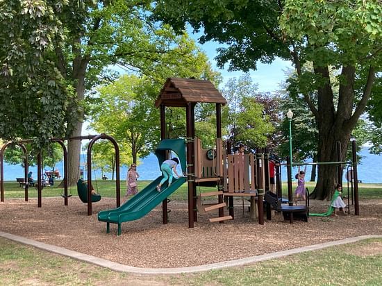 wooden slide in the playground surrounded by trees