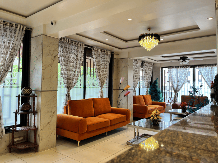 The lobby with orange couches placed in front of coffee tables at VITS Select Kharadi, Pune, the most convenient hotel near Pune International Airport