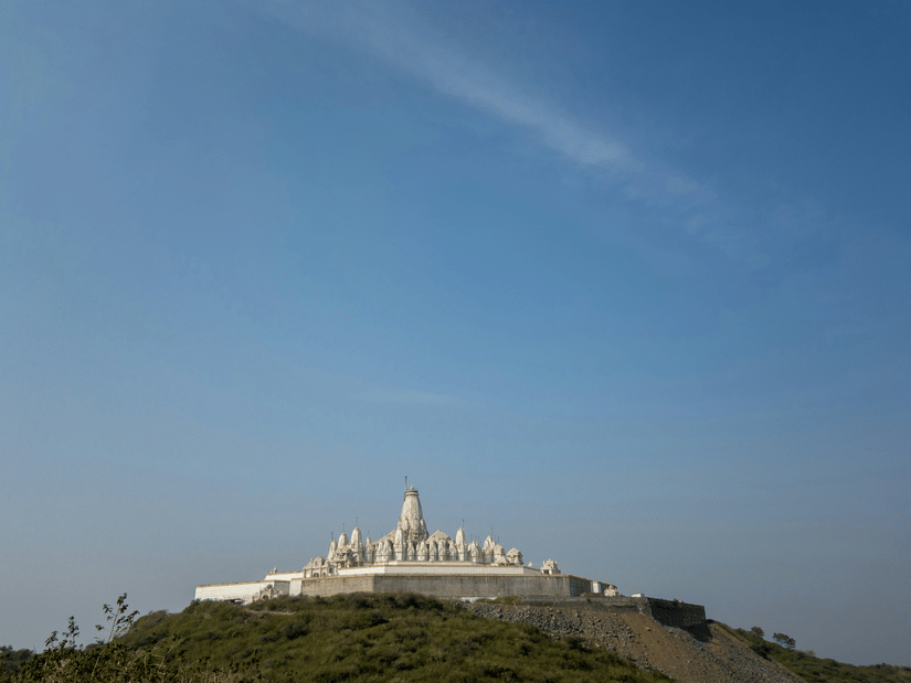 Parasnath Jain Temple on a hilltop as seen from afar with blue sky in the background - Parasnath Jharkhand