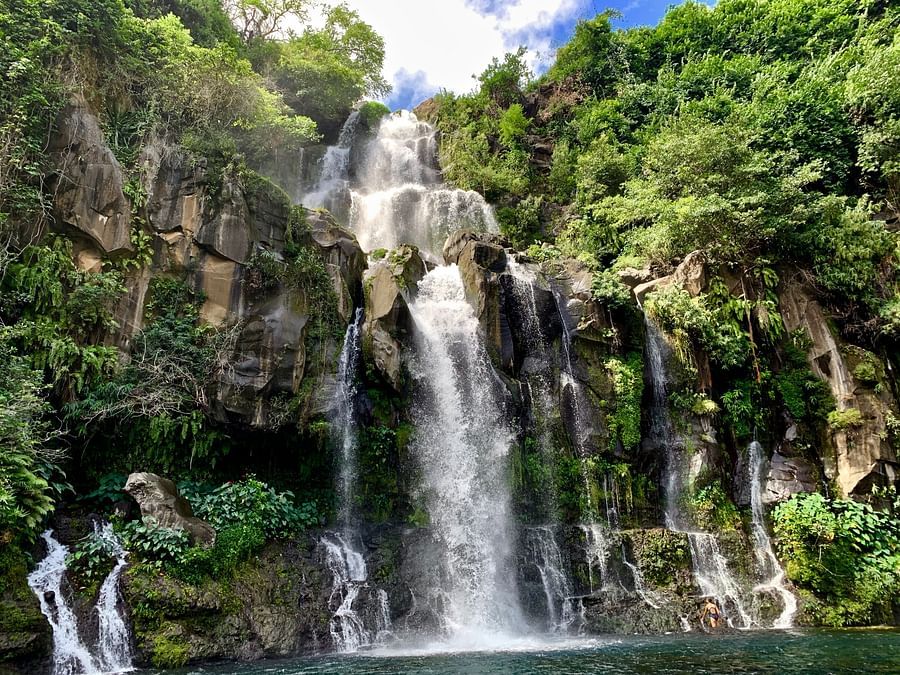 cascading waterfall surrounded by lush green mountains.