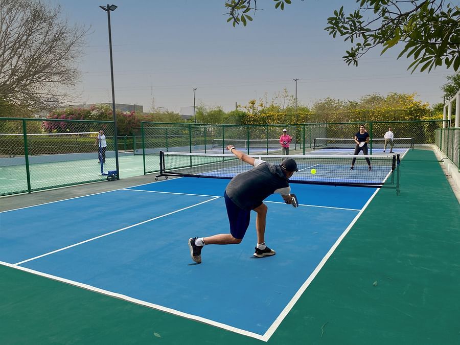 Guests playing pickleball on an outdoor court.