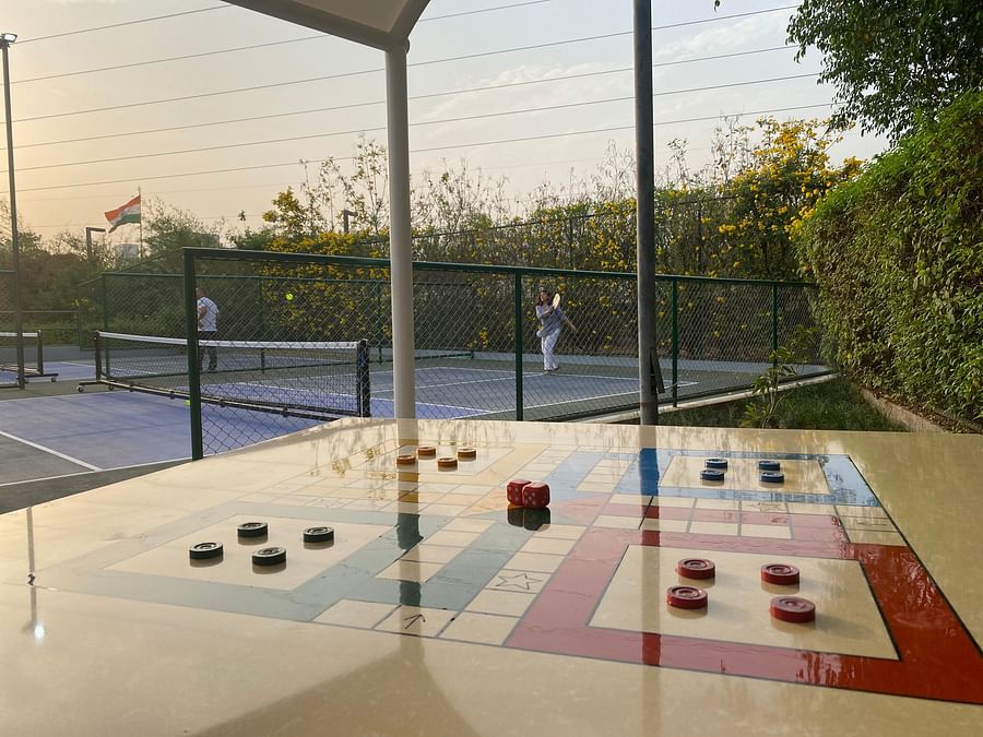 Outdoor games setup with a court and a ludo board.