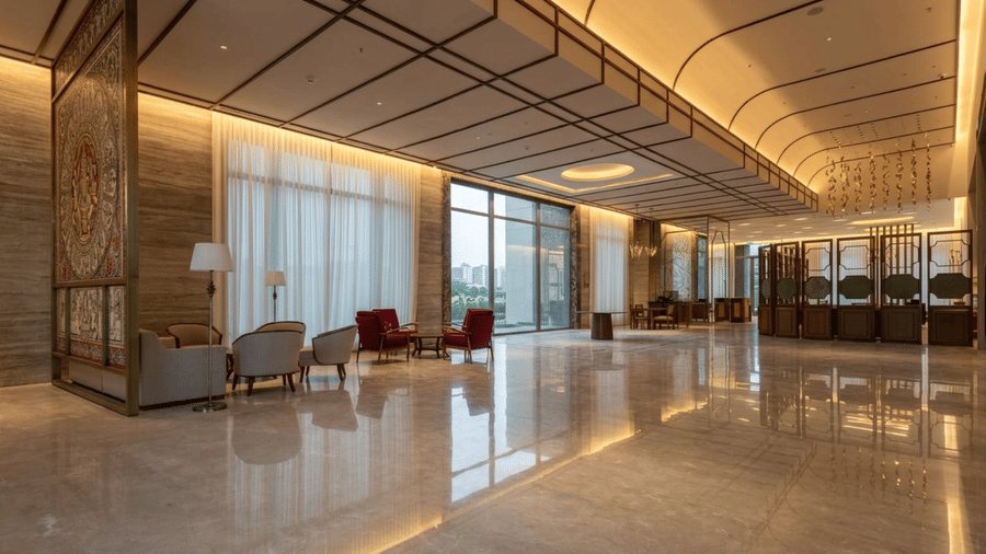 Lobby of Prachi Sarovar Premiere, Bhubaneswar featuring a spacious lobby with seating, and a reception desk in the corner.