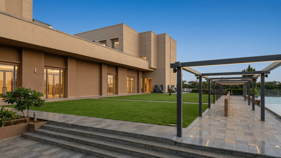 A manicured lawn at Prachi Sarovar Premiere, Bhubaneswar, situated beside the hotel building on one side and a walkway on the other.