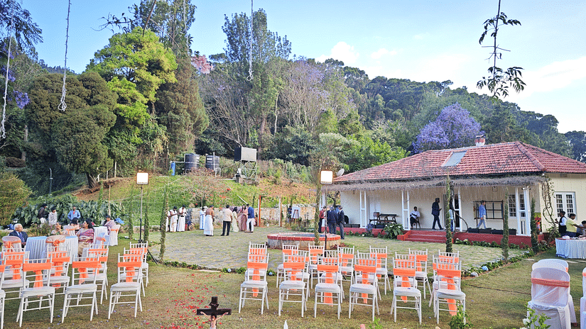 Wedding setup in Coonoor with rows of chairs and a central water feature under a tree adorned with purple flowers - Ibex Stays & Trails, Coonoor (Leewood).