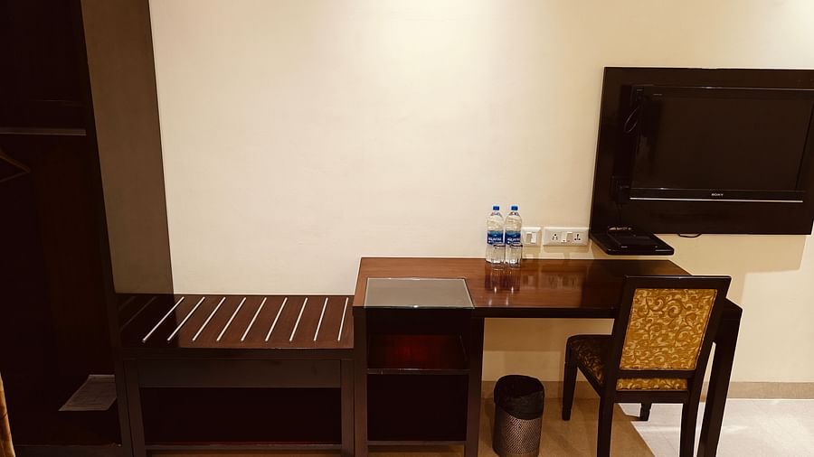Work desk and television setup in a clean, twin-sharing room at Hotel Alps Residency, Krishnagiri.