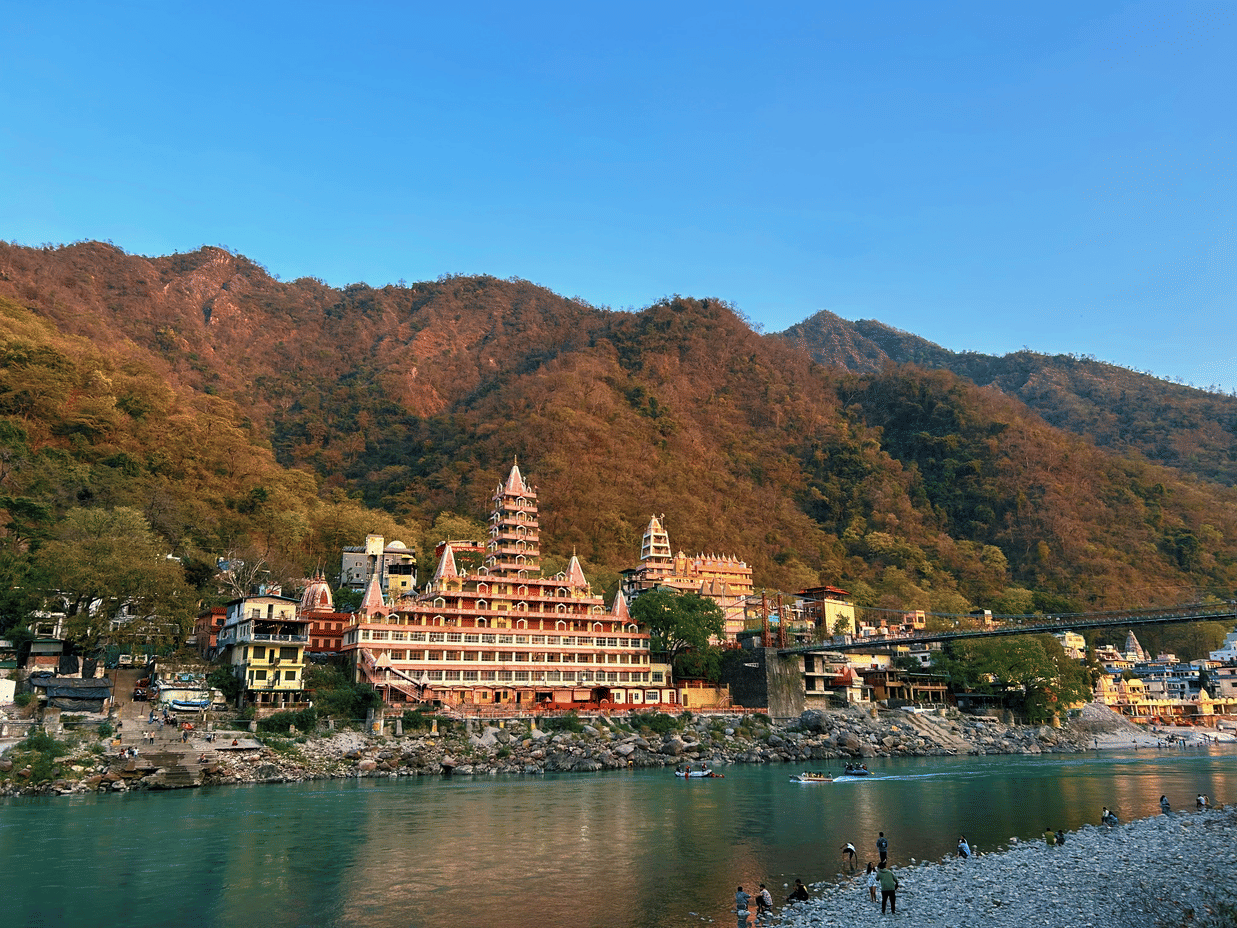 Scenic view of a temple with a river in the front and hills in the background.