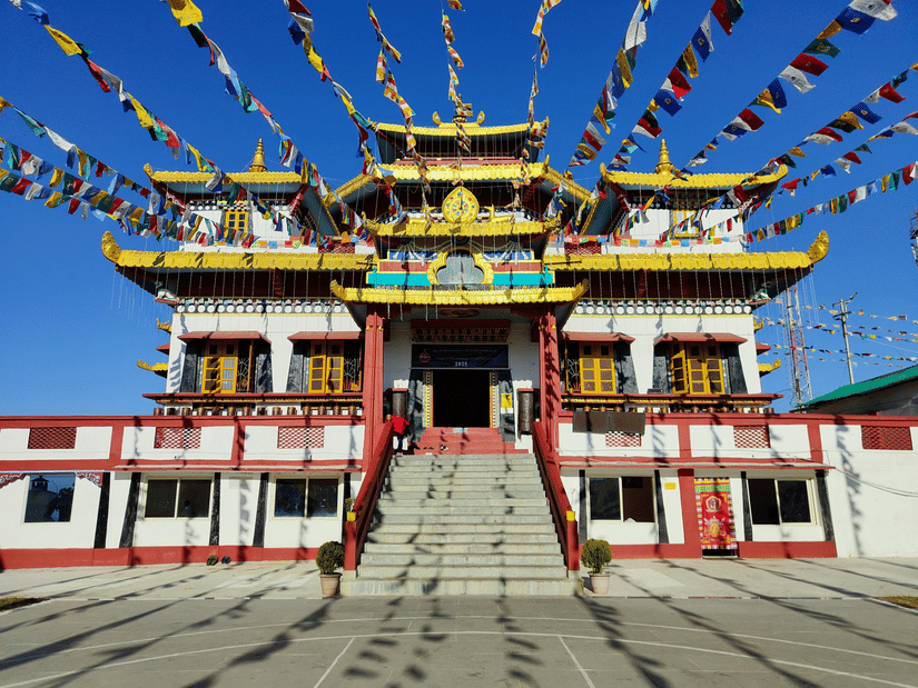 The Ghoom Monastery adorned with colourful prayer flags and traditional architecture under a clear blue sky in Darjeeling.