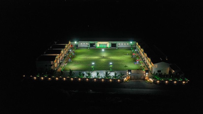A bird's eye view of the resort amidst pitch black darkness illuminated at night, with surrounding lights outlining the area - VITS Select Diamond Resort, Sasan Gir