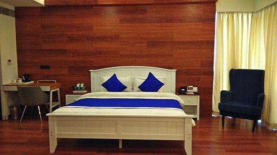 a bed with blue pillows and duvets