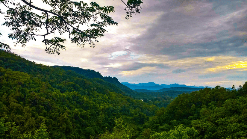 View of lush greenery covering the mountains in the surrounding under a vibrant sky