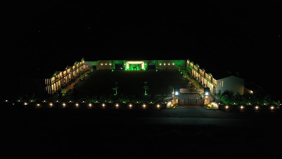A distant view of the resort entrance, with path lights and the grand gate illuminated at night - VITS Select Diamond Resort, Sasan Gir