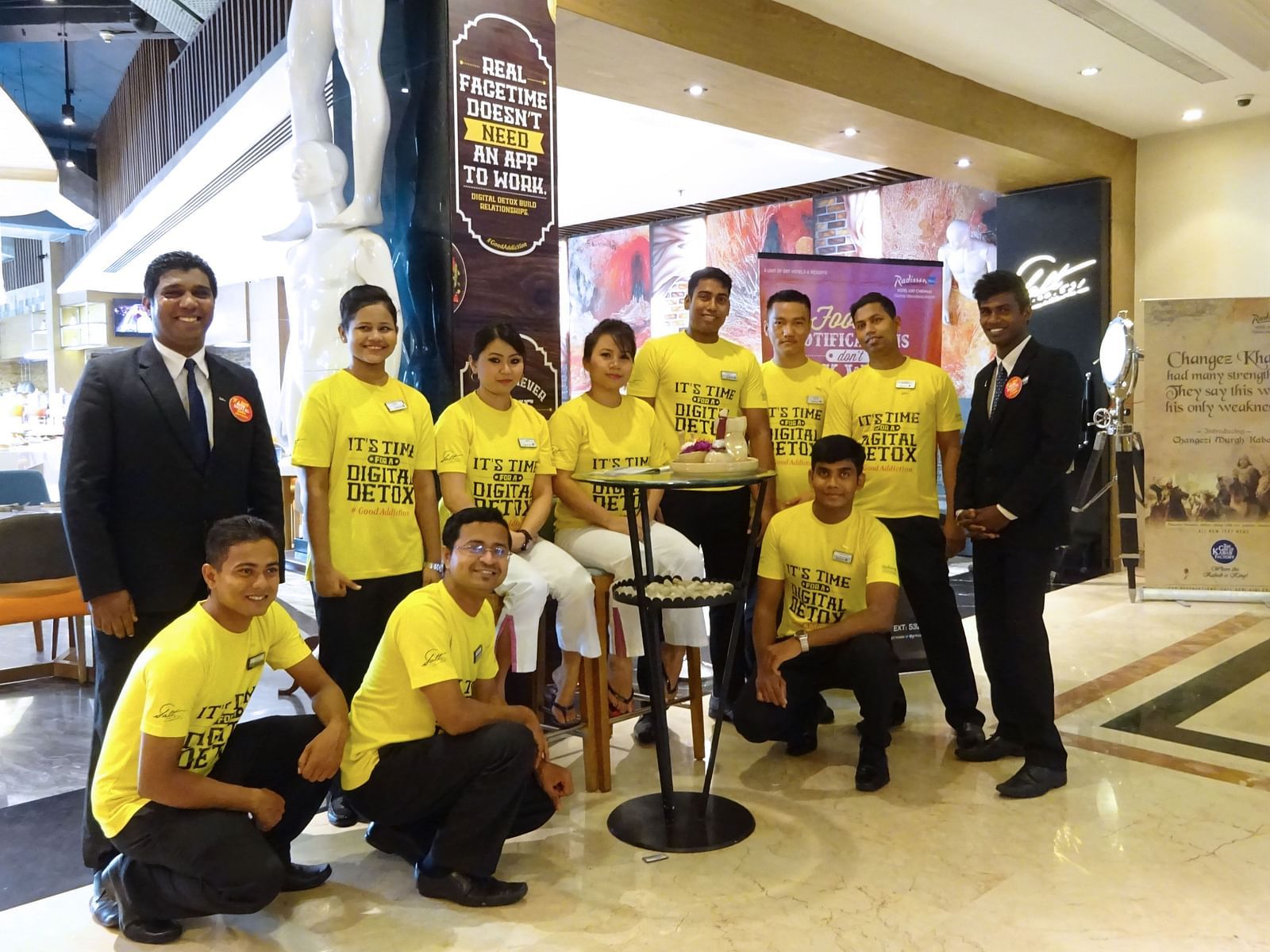 Group of people in yellow shirts posing together at an event.