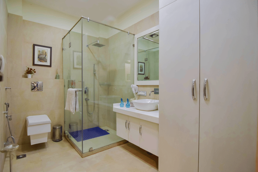A bathroom of a room at the resort featuring a shower room, a sink, vanity mirror, toilet, and a cupboard.