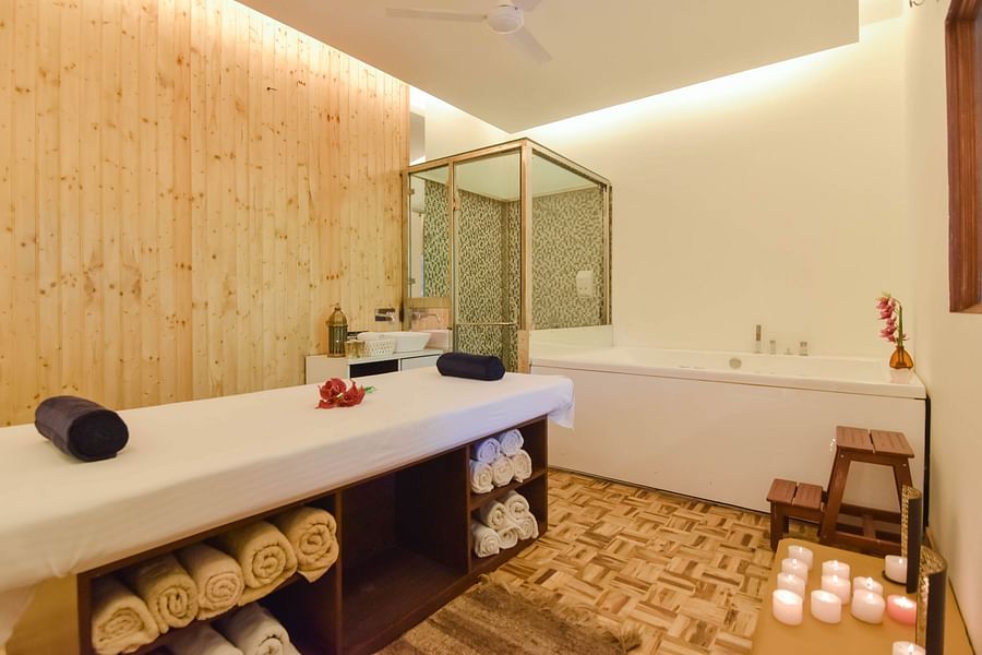 A relaxing spa room with a massage table and candles.
