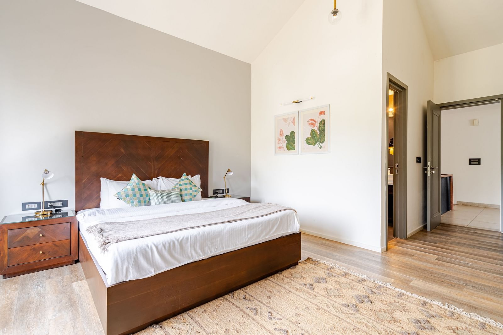 Spacious bedroom at Lindsay Manor with a double bed, modern decor, side tables, wall art and white interiors.