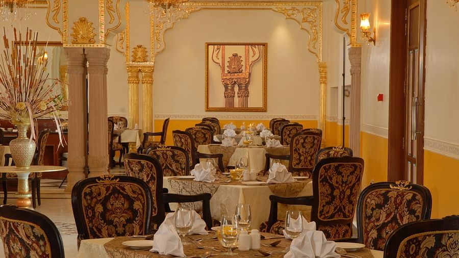 Image of a dining space with seating area a photo frame on the wall at Rajasthali Resort & Spa Jaipur.