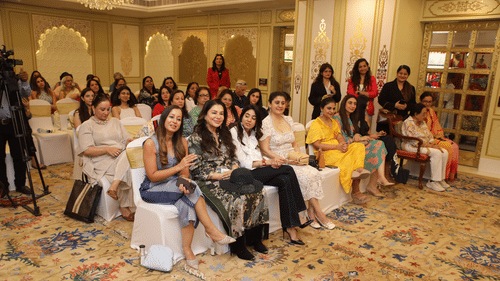 Group of women attending an elegant Golf event in a luxurious hall with ornate decor.