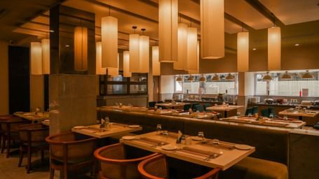 A warm and welcoming restaurant interior with stylish lighting and comfortable dining chairs at Shilton Dee Cee.