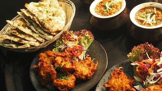 Indian food items placed along bread platter