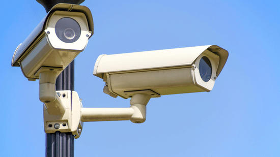 A pair of security cameras mounted on a pole.