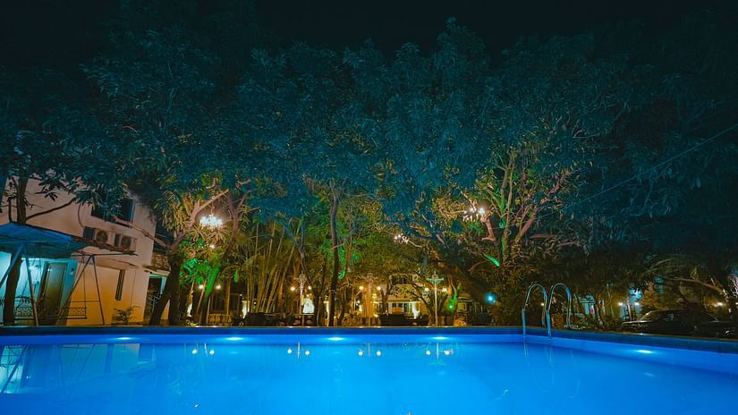 An image of a Swiming Pool with having some trees around and a building at Rangamati Garden Resort