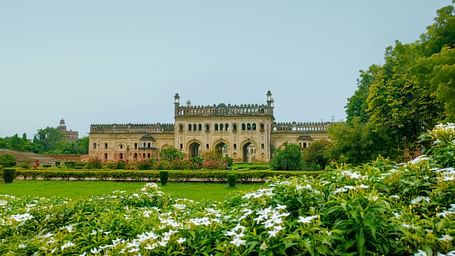 view of Bada Imambara in Lucknow from a garden with flowers and trees