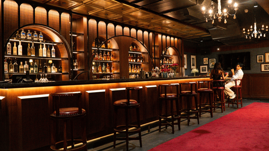 Elegant bar at Mango Hill Central Chennai with warm lighting, premium liquor display, and cozy seating for a relaxed evening.