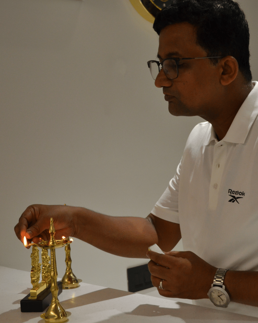 A guest lighting a brass diya at Signum Tathastu Boutique Hotel, Haridwar