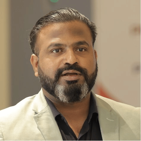 Senior team member portrait in formal attire at Pride Hotels Group.