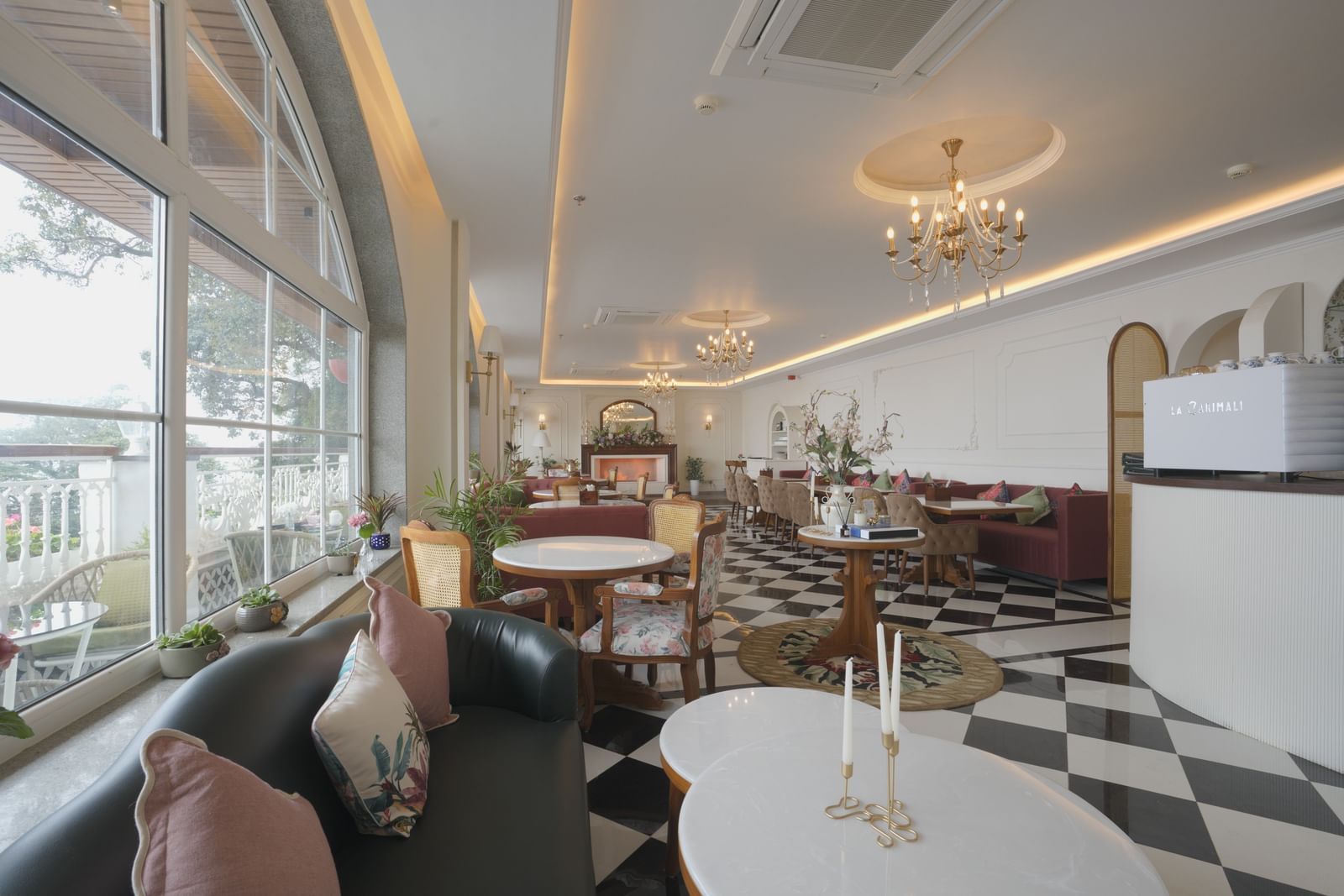 Stylish cafe interior with natural lighting, white tables, and cushioned seating - Mayfair Cafe & Suites, Dalhousie