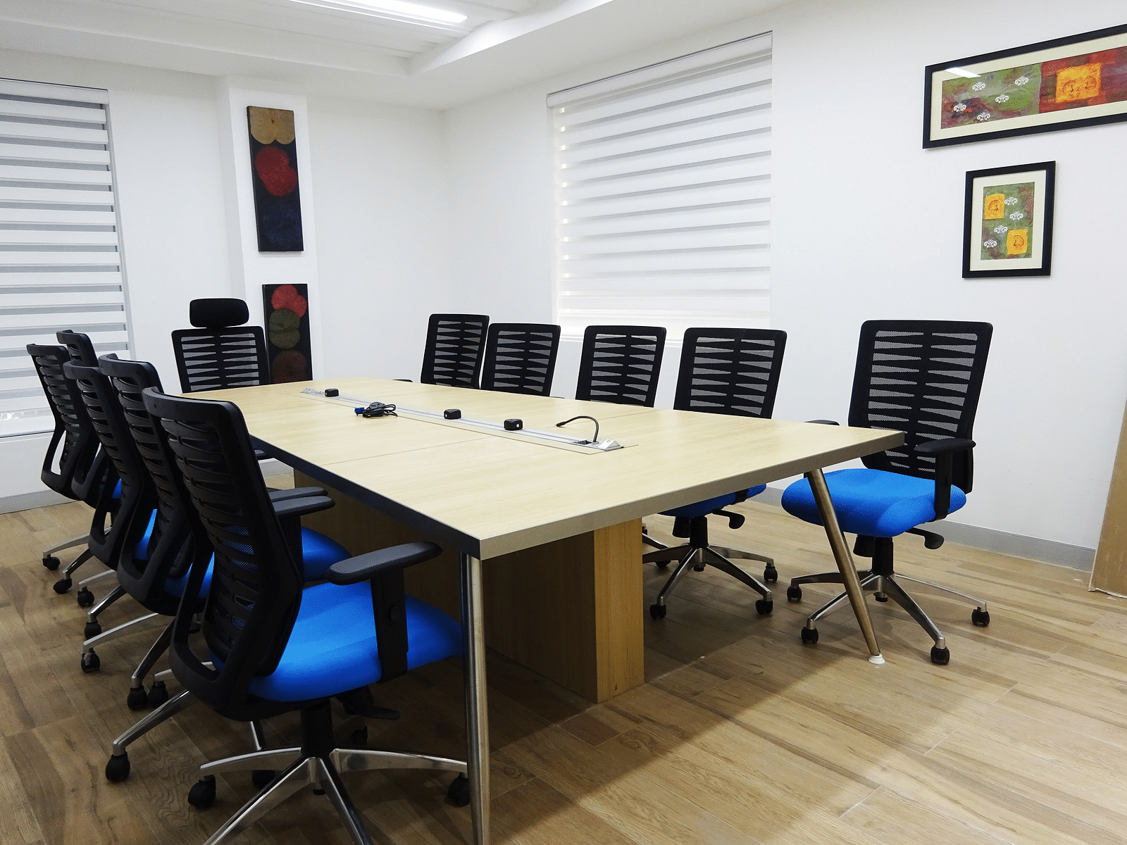 A view of a conference room with a big table surrounded by chairs.
