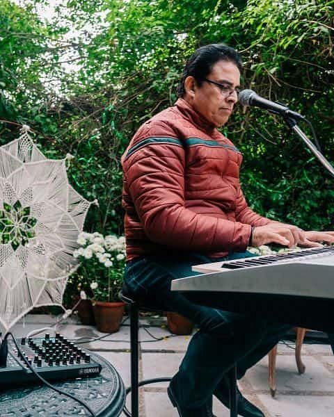 Musician playing a keyboard and singing at an outdoor event at Karma Chalets