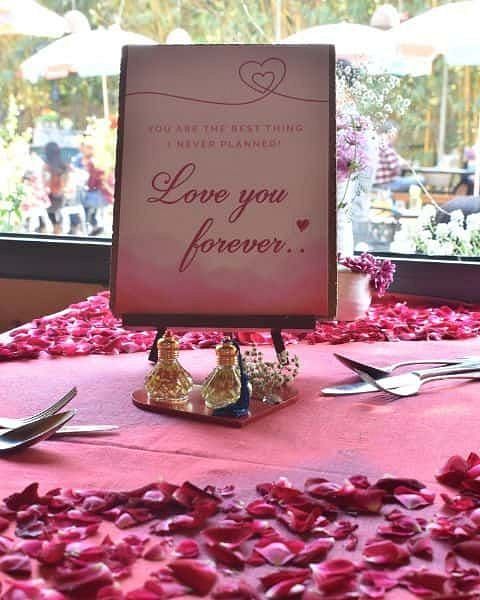 Table set with rose petals and a sign reading Love you forever at Karma Chalets.