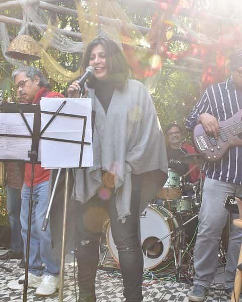 Band performing live music with a female vocalist at Karma Chalets garden event.