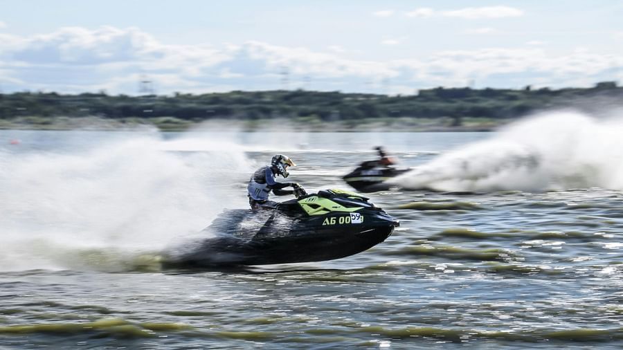 Two people riding jet skis on a cloudy day