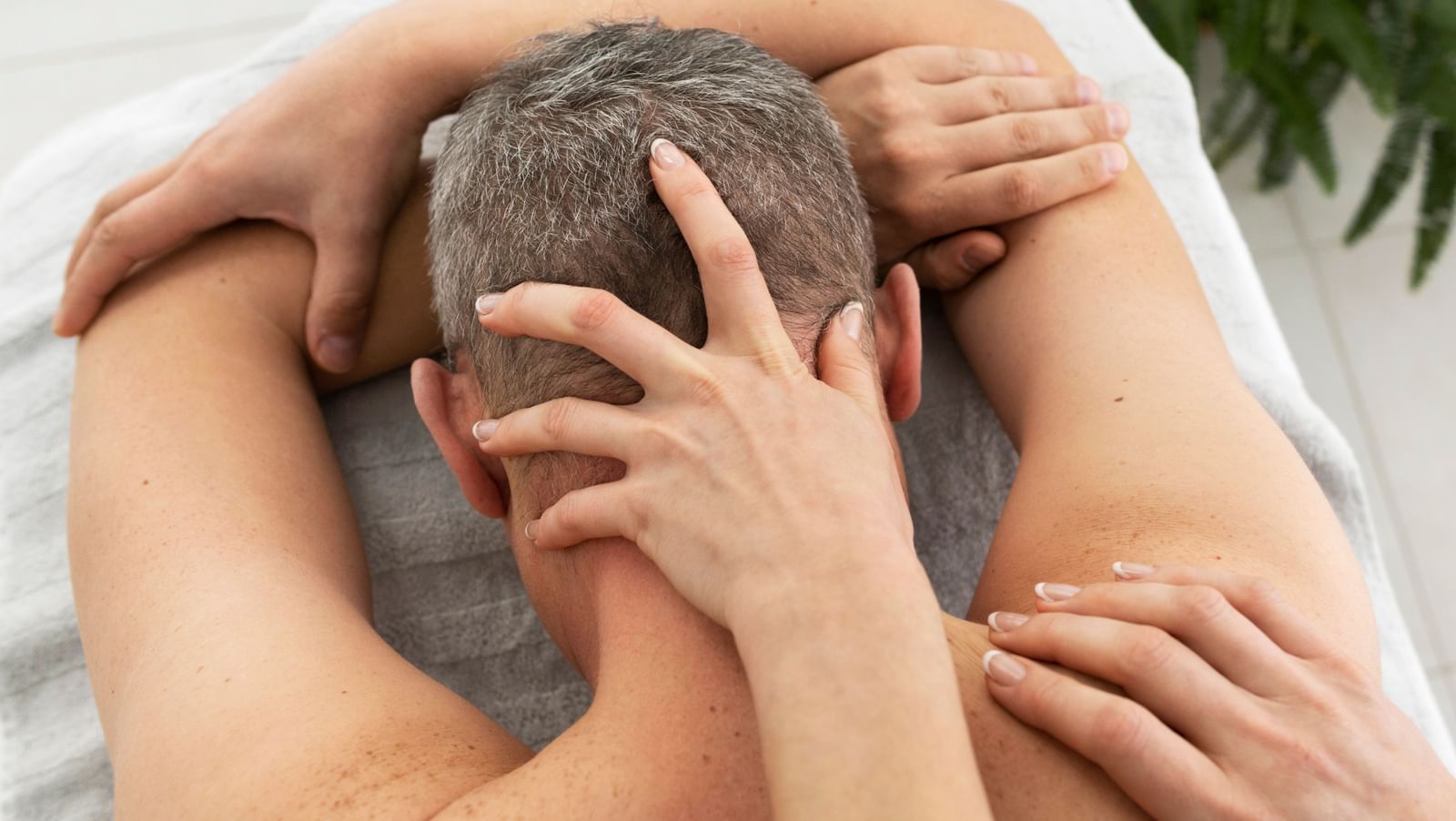 A relaxing massage with gentle hands working on the neck and shoulders of a patient.