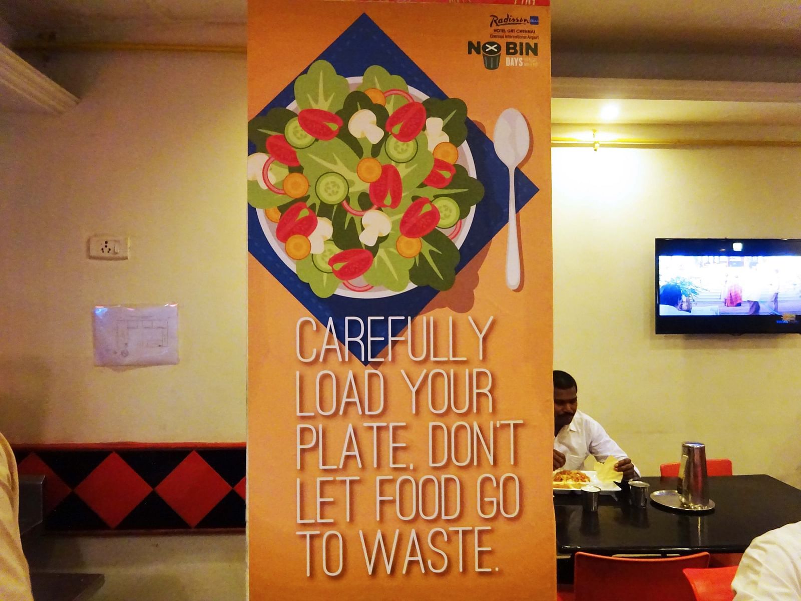 Image showing the inside of a restaurant with a banner that tells not to waste food.