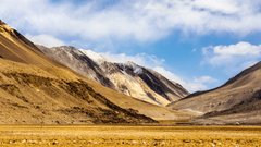 A picturesque valley with a sky partially covered with clouds in the background.