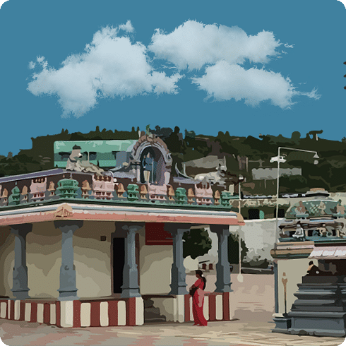 A white temple building with colourful details, a red staircase and a blue, cloudy sky.
