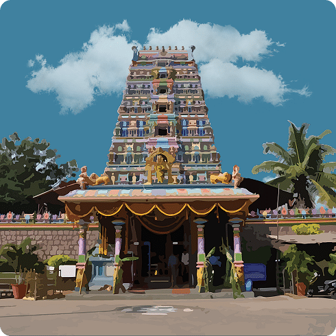 The multi-tiered, ornate gopuram of a temple with a golden spire and colourful sculptures.