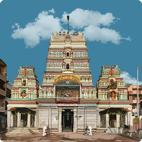 A detailed temple with a blue sky, showcasing colourful carvings and a towering gopuram.