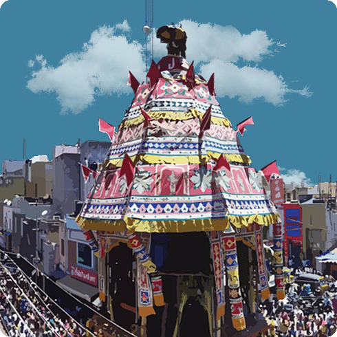 A towering temple chariot in a street, surrounded by a large crowd of devotees.