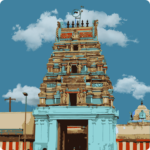 A colourful temple gopuram with intricate carvings and a blue base, under a cloudy sky.