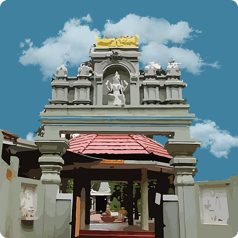 An ornate temple entrance with a grey facade, sculptures, and a covered gateway under a cloudy sky.