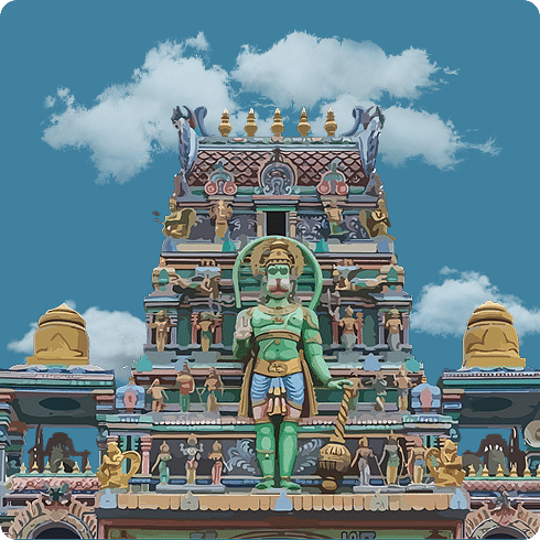 A vibrant South Indian temple with a towering gopuram adorned with intricate deities and vivid colours.