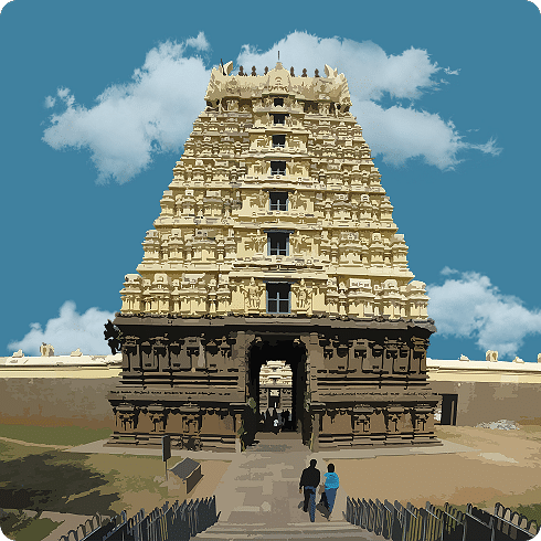 A majestic temple entrance with a grand gopuram and people strolling below on a clear day.