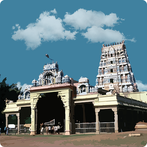A temple complex with twin gopurams under fluffy white clouds.