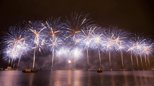 Fireworks being burst over a waterbody at night