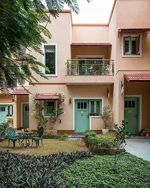 Exterior view of Karma Chalets with balconies, windows, and garden landscaping.